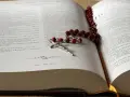 Modlitwa za zmarłą żonę. Różaniec na otwartej księdze, symbol wiary i pamięci.