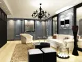 Elegancki salon w gotyckim stylu, z czarnym żyrandolem, kremową sofą i fotelem, ozdobiony lustrami i geometrycznymi akcentami.