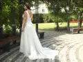 Piękna panna młoda w zwiewnej sukni ślubnej w ogrodzie. Dowiedz się, jak przechowywać suknie ślubną, by zachowała swój urok.