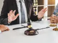 Un avocat explique les démarches pour un papier divorce mairie. Marteau de juge, alliances et balance de la justice sur la table.