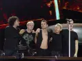 Les membres de Depeche Mode sur scène, souriants et complices, profitent de l'instant.