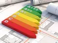 Kolorowy wskaźnik klasyfikacji energetycznej budynku od D do A+++ leży na planach architektonicznych.