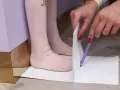 Dziecko mierzy stopę, by dowiedzieć się, jaki to rozmiar buta. 15 cm to idealny pomiar dla małych stópek.