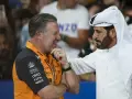 Mohammed Ben Sulayem, con túnica blanca, conversa animadamente con un hombre con polo naranja de McLaren.