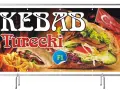 Kebab turecki z frytkami i flagą Turcji na tle płomieni.