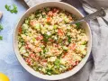 Frischer bulgur salat mit Tomaten, Gurken und Frühlingszwiebeln, garniert mit Petersilie.