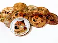 Kryptowaluta Doge w postaci złotych i srebrnych monet, z wizerunkiem psa Shiba Inu i napisem "WOW".