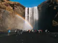 Turyści pod wodospadem Skógafoss na Islandii. Czy do Islandii trzeba mieć paszport? Tak, dla obywateli spoza strefy Schengen.