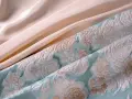 Tissu texturé bleu ciel avec des motifs floraux et un tissu satiné pêche. Parfait pour une robe d'été élégante.