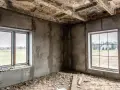 Wnętrze w budowie, dwa okna wychodzą na pola. Odległość okna od granicy działki i zgoda sąsiada to kluczowe kwestie przy planowaniu.