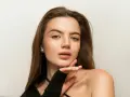 Delikatny makijaż nude podkreśla naturalne piękno młodej kobiety. Jej skóra lśni subtelnym blaskiem, a usta kuszą delikatnym kolorem.