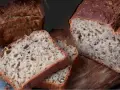 Chleb gryczany z ziarnami, pokrojony w kromki, prezentuje się apetycznie na drewnianej desce.