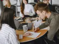Uomini e donne in riunione, concentrati sul lavoro. Le 40 ore settimanali sono un impegno serio per raggiungere gli obiettivi.