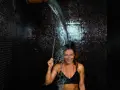 Donna sorridente riceve una doccia gelata, godendosi i benefici rivitalizzanti.
