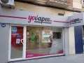 Tienda "yovapeo.es" de cigarros electrónicos. Un cartel anuncia "vaper quema garganta" con ofertas.