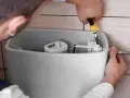 Hydraulik naprawia spłuczkę, która przepuszcza wodę. Wymienia mechanizm zaworu.