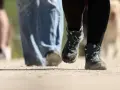 Wanderstiefel in Aktion, die den Boden aufwirbeln. Die boot geschwindigkeit ist spürbar, während die Wanderer voranschreiten.