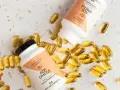 Dwie butelki i rozsypane kapsułki suplementu ACP Omega, zawierającego kwasy omega 3.