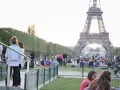 Gente disfrutando de un día soleado en París, con la Torre Eiffel de fondo. Un momento perfecto para la bise en France.