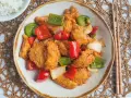 Delicioso pollo agridulce con pimientos rojos y verdes, y cebolla. Un plato vibrante y sabroso, listo para disfrutar.