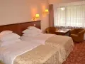 Przytulne hotel Gołębiewski pokoje z dwoma wygodnymi łóżkami, stolikiem i dwoma fotelami.