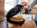Nach dem Genuss von Waffeln wird das Waffeleisen gereinigt.
