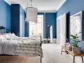 Accogliente camera da letto blu con letto comodo, armadio scuro e specchio a figura intera.