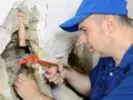 Klempner repariert Wasserhahn. Ein Rohrbruch, für den die Versicherung nicht zahlt, ist eine teure Angelegenheit.
