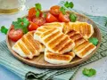 Grillowany ser halloumi z pomidorkami koktajlowymi i kolendrą. Idealny pomysł, co zrobić z sera halloumi na lekki posiłek.