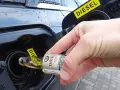 Dłoń wlewa dodatek do benzyny do baku samochodu z napisem DIESEL.