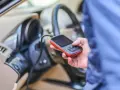 Diagnostyka Renault, być może błąd DTC B1267. Ręka trzyma urządzenie diagnostyczne podłączone do samochodu.