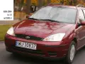 Czerwony Ford Focus Mk1 1.6 benzyna z lat 1998-2004, poruszający się po drodze.