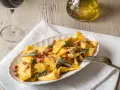 Piatto di casoncelli alla bergamasca conditi con burro, salvia e pancetta croccante.