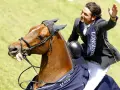 Un cavalier, Nino des Buissonnets, salue la foule depuis son cheval après une compétition.