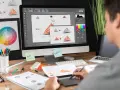 Diseñador gráfico trabajando en un logo, con paleta de colores y bocetos. Imágenes libres de derecho de autor.