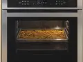 Horno con una bandeja llena de patatas fritas en su interior.