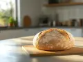 Ein frisch gebackenes Brot liegt auf einem Holzbrett. Der Teig ging perfekt auf, ein Beweis, dass der Sauerteig diesmal stimmte.