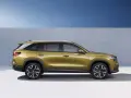 Złoty skoda suv z nowoczesnymi felgami stoi na tle niebieskiego nieba i szarej ściany.