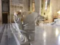 Marmorengel in einer Kathedrale, der betet. Die Skulptur erinnert an einen bibel verse über Hoffnung und Glauben.