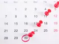 Calendario con chinchetas rojas marcando días. El día 30 está rodeado, recordando que en hostelería se pagan los festivos.