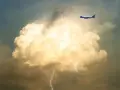Samolot leci obok burzowej chmury z błyskawicami. To pokazuje, co to są turbulencje.