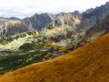 Widok na Tatry jesienią. Widać szlak turystyczny, którym idzie się na Kasprowy, małe stawy i skaliste szczyty.