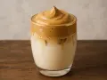 Puszysta pianka kawowa na mleku z lodem. Idealny dalgona coffee przepis na orzeźwiający napój.