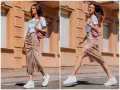 Kobieta w błyszczącej spódnicy i białej koszulce prezentuje miejski styl. Jej stylizacja to kwintesencja street fashion.