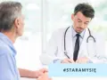 Dermatolog wenerolog w białym kitlu rozmawia z pacjentem, notując coś. #STARAMYSIĘ