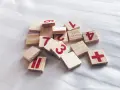 Drewniane klocki z cyframi i symbolami, jakby ktoś układał zadanie na **2 rok numerologiczny**.