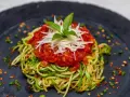 Deliciosa pasta con verduras, hecha de calabacín en espiral, cubierta con salsa de tomate y queso rallado.