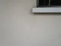 Crepa sottile su muro esterno, vicino a davanzale e inferriata. Necessaria riparazione crepe strutturali.