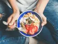 Un bol coloré de fruits, noix et graines, parfait pour une collation après sport.