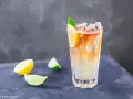 Orzeźwiający drink Long Island Iced Tea z plasterkami cytryny i limonki, idealny na upalne dni.